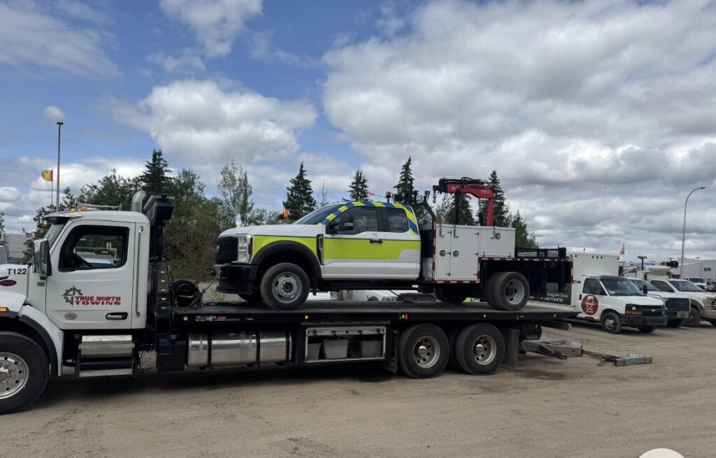 Tow truck loaded on a flatbed truck for vehicle transport and roadside assistance