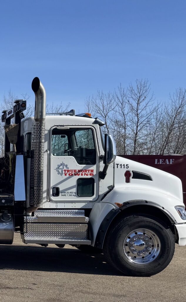 Closeup of side of white True North Automotive branded semi truck