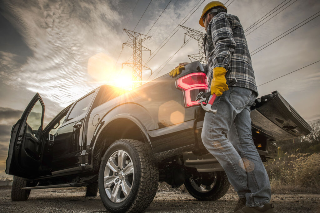 Construction worker at job site walking around the rear of a truck